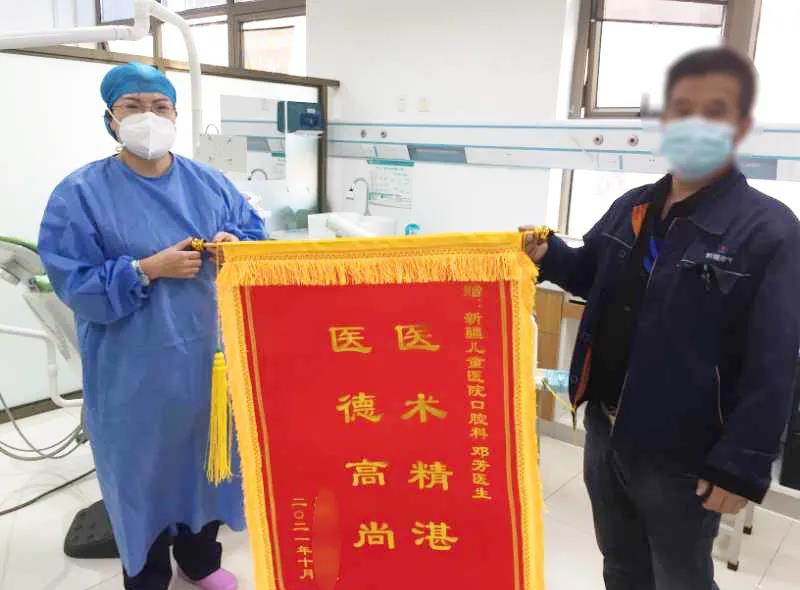 文5-1-1朱先生将锦旗送到口腔科医生邓芳手中 文5-1-1朱先生将锦旗送到口腔科医生邓芳手中